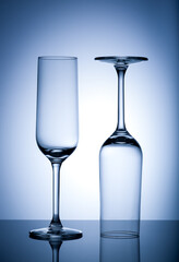 Two Empty wine glasses isolated on blue background.