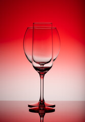 Two Empty wine glasses isolated on red background.