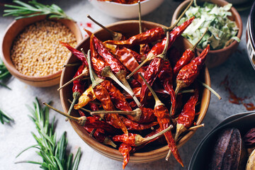 Colorful indian spices and herbs in bowls on light concrete table