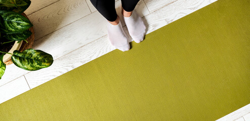Woman legs on an exercise mat with copy space. Preparing to do yoga at home. Female practicing yoga.