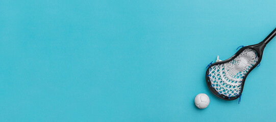 Lacrosse stick and white  ball on blue background. Lacross is a team sport