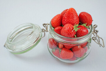 fresh srawberry in a jar on a white background