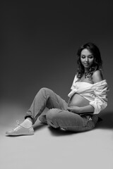 Obraz na płótnie Canvas Black and white studio photo of a pregnant woman. Pregnancy and expecting a baby concept