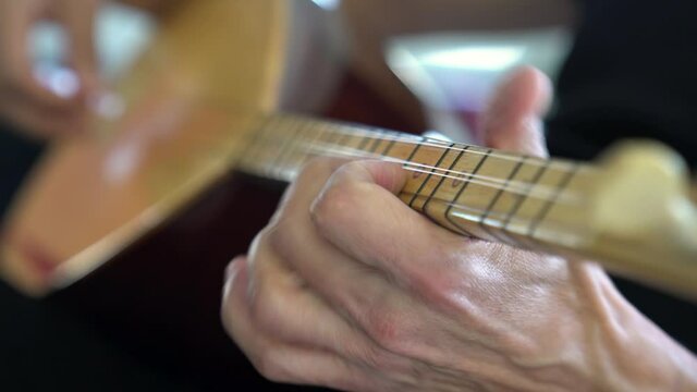 Male hands playing traditional music Instrument close up.Adult hobby course
