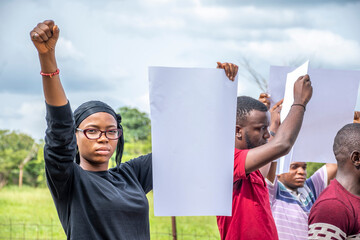 group of protesting young black african people holding up signs with free copy space