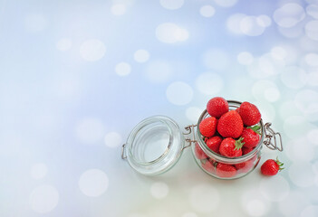 Obraz na płótnie Canvas jar with fresh strawberries on a a blue defocused background with copy space