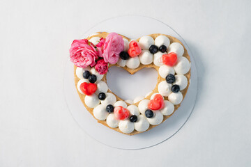 Homemade heart shaped cake on white table. Food delivery. Homemade baking. Top view.