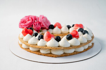 Homemade heart shaped cake on white table. Food delivery. Homemade baking. Side view.