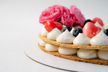 Homemade heart shaped cake on white table. Food delivery. Homemade baking. Close up side view.