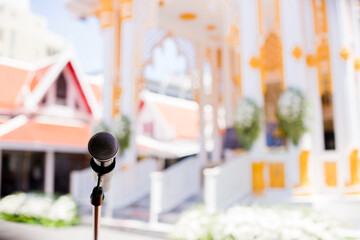 Microphone with blurry outdoor location for Buddhist activities. The concept of speaker.