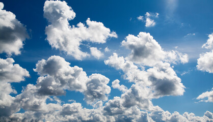 Naklejka na ściany i meble Cumulus white-grey clouds against the blue sky