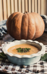 Pumpkin and carrot cream soup on the dark wooden table. Healthy food.