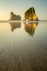 Ocean beach at sunset with rock reflection