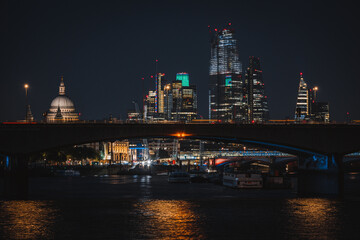 Bright nigh skyline of London city with the financial district skyscrapers, St Paul's Cathedral and the Thames river 