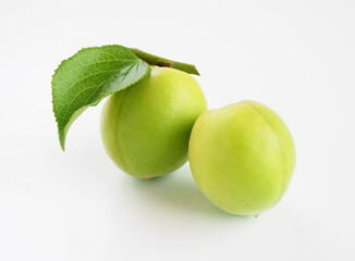 葉のついた青梅を白背景で
