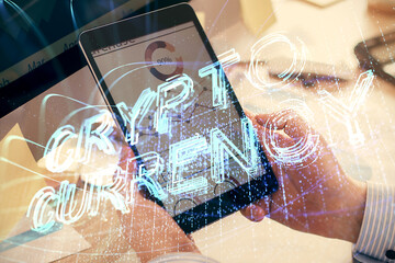 Double exposure of man's hands holding and using a phone and crypto currency blockchain theme drawing.