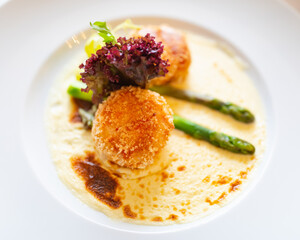 crab meatballs fried with asparagus on white plate