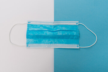 Surgical mask on blue and white background.