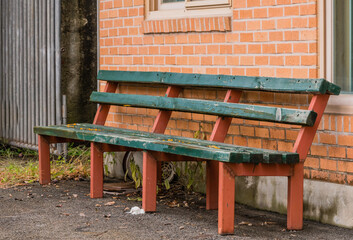 Wooden bench against brick wall