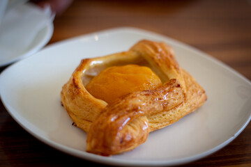 Peach puff bun on a white plate.