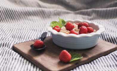 Breakfast. Tasty oatmeal with berries. Healthy breakfast ingredients. Oat granola in bowl with strawberry and mint. Granola for breakfast with berries.