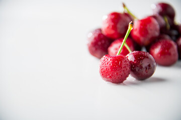 Ripe red cherries on white background.