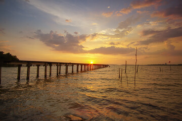Naklejka na ściany i meble Beautiful sunset scenery at seascape with long jetty background.