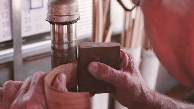 Professional guitar maker bending wood for acoustic guitar body. Workshop labour in Madeira
