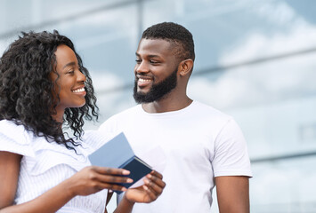 Portrait of happy black couple with passports and tickets in hands