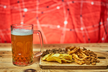 A glass of beer and different snacks on the table. Celebrating international beer day or Octoberfest. Drinking beer after a hard working day or week
