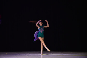 Young teenage girl performing modern dance on stage