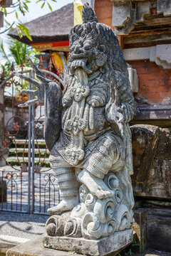 Stone statue of Rangda at Balinese Hindu Pura Dalem (Temple of the Dead) entrance, Gianyar, Bali, Indonesia. Vertical image.