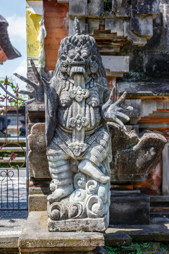 Stone statue of Rangda at Balinese Hindu Pura Dalem (Temple of the Dead) entrance, Gianyar, Bali, Indonesia. Vertical image.