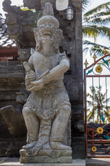 Statue of Sang Suratma god at Balinese Hindu Pura Dalem (Temple of the Dead) entrance, Gianyar, Bali Island, Indonesia. Vertical image.