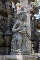 Fototapeta na wymiar Statue of Sang Suratma god at Balinese Hindu Pura Dalem (Temple of the Dead) entrance, Gianyar, Bali Island, Indonesia. Vertical image.