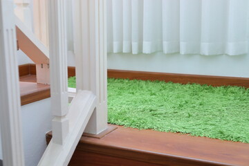 green carpet covering on laminate wooden stair