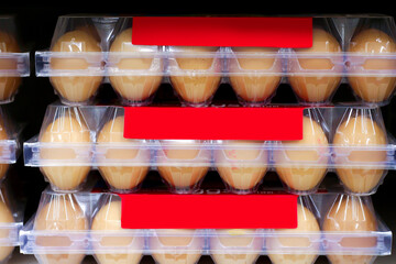 Chicken eggs in a transparent plastic tray on shelf in supermarket