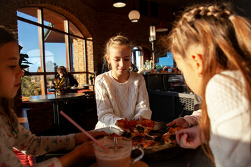 Top view image of children hands grab slice pizza. Group of kids eating italian food in in cafe. Hungry children holding appetite piece of tasty pizza. People celebrating birthday in pizzeria.