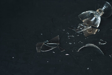 Broken and smashed wineglass on a black background with copy space