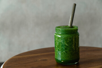 Green apple spinach smoothie in glass jar with eco-friendly reusable metal straw. Healthy summer refreshment drink. Safe for environment. Copy space