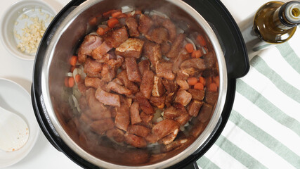 Cooking rice with meat and vegetables  in pressure multi cooker step by step. Add chopped, marinated meat.