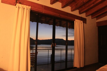 Vista de lago y montañas a través de la ventana al amanecer
