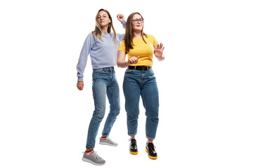Obraz premium Young girls girlfriends in jeans dance emotionally. Festive cheerful mood. Isolated on a white background.