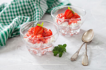 summer breakfast - cottage cheese with strawberry in a glass bowl on a table, selective focus