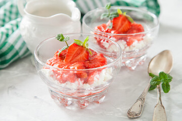 summer breakfast - cottage cheese with strawberry in a glass bowl on a table, selective focus