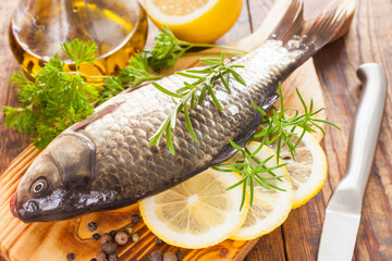 fish with a lemon and tomatoes on a table, selective focus