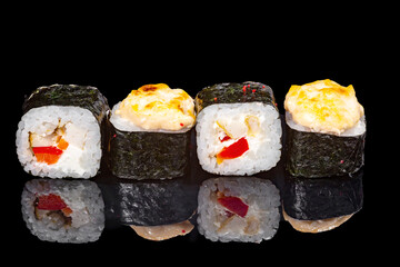 Sushi and rolls on a black mirrored background.