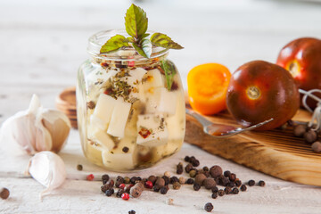 marinated cheese in oil with spices in a jar, selective focus