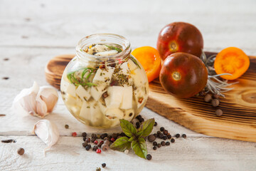 marinated cheese in oil with spices in a jar, selective focus