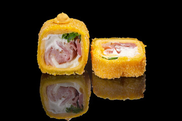 Sushi and rolls on a black mirrored background.